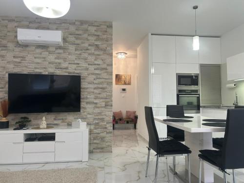 a living room with a television and a table with chairs at Wellness Way in Dunajská Streda