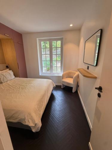 a bedroom with a bed and a window and a chair at Montignac Lascaux Home 