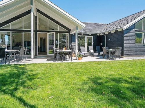a patio with tables and chairs on a lawn at 5 star holiday home in Kappeln in Kappeln