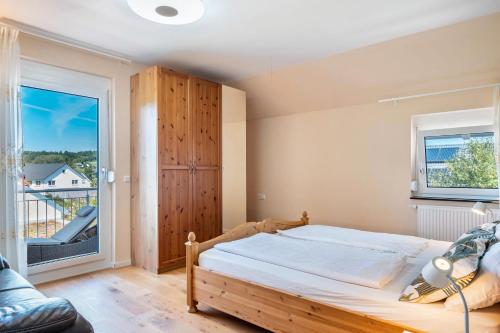 une chambre avec un lit et une grande fenêtre dans l'établissement Haus Rosengarten, à Friedenweiler