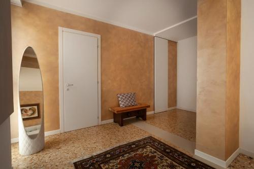 an empty hallway with a bench and a door at T-Rooms in Bassano del Grappa
