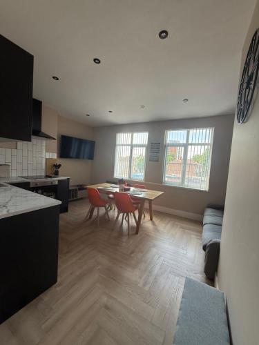 a kitchen and living room with a table and chairs at Stylish and Bright 2 Bedroom Flat Free Parking in Wallasey