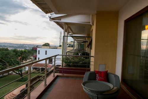 a balcony with a table and a chair on a building at Enkombe Place in Kampala