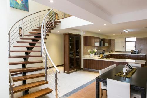 a kitchen and dining room with a spiral staircase in a house at Enkombe Place in Kampala