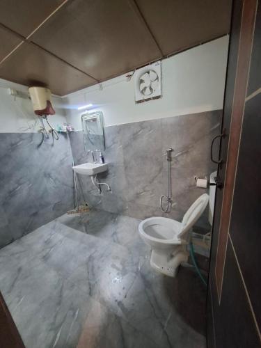 a bathroom with a toilet and a sink at Prime Cottage 2bhk independent cottage home in Dimāpur