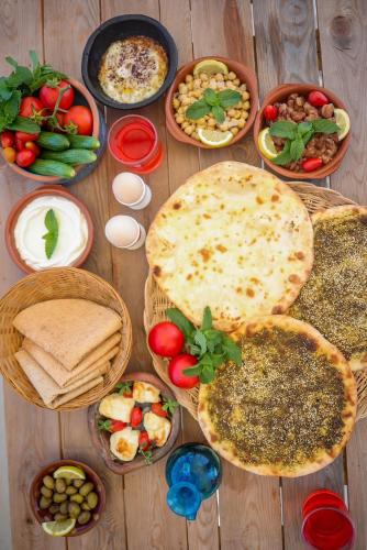 a wooden table with many plates of food on it at Beitkamle in Batroûn