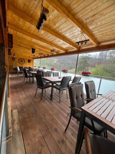 a dining room with tables and chairs on a deck at Gasthaus Casa Kugler in Anina