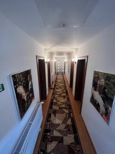 a hallway with pictures on the walls of a building at Gasthaus Casa Kugler in Anina