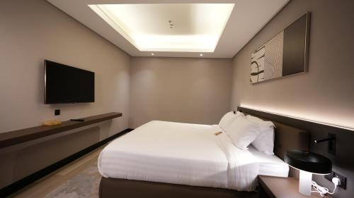 a hotel room with a bed and a television at Snood Al Narjis Hotel in Riyadh