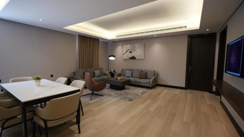 a living room with a table and a couch at Snood Al Narjis Hotel in Riyadh