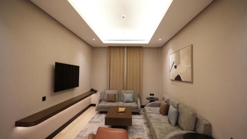 a living room with a couch and a tv at Snood Al Narjis Hotel in Riyadh