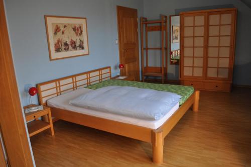 a bedroom with a bed and a wooden floor at Hotel Cramer Bed & Breakfast in Werlte