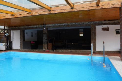 a large blue swimming pool in a building at Gasthaus Casa Kugler in Anina