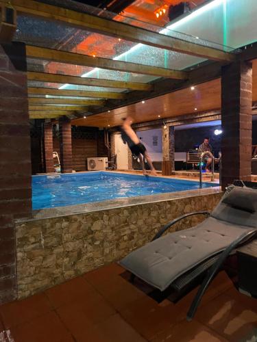 a swimming pool with a person diving into it at Gasthaus Casa Kugler in Anina