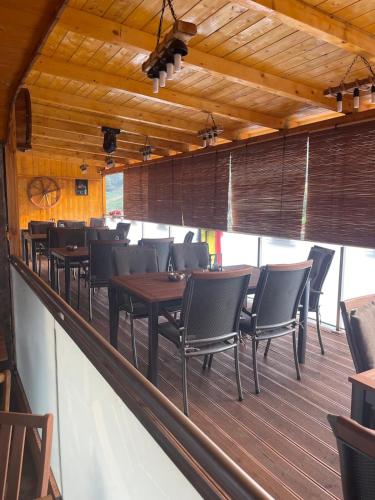 a row of tables and chairs on a deck at Gasthaus Casa Kugler in Anina