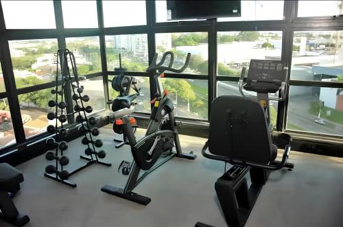 a gym with exercise equipment in front of a window at Edifício Concept in Marília
