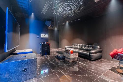 a living room with a leather couch and a tv at TML urban 4 bedroom 6 bathroom villa private KTV room and swimming pool in Pattaya South