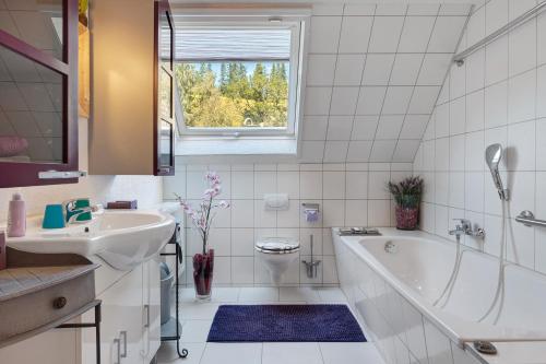 a bathroom with a tub and a sink and a toilet at Grundhäusle Gütenbach in Gütenbach