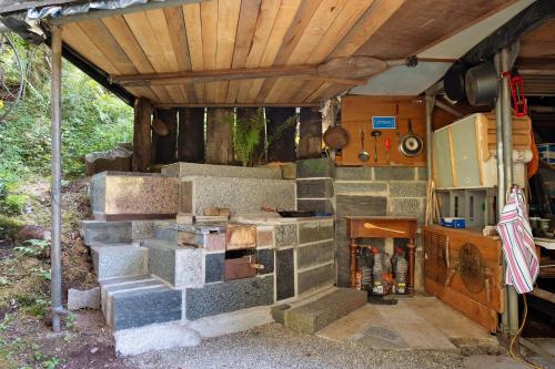 an outdoor kitchen with a stone stove in a house at Grundhäusle Gütenbach in Gütenbach