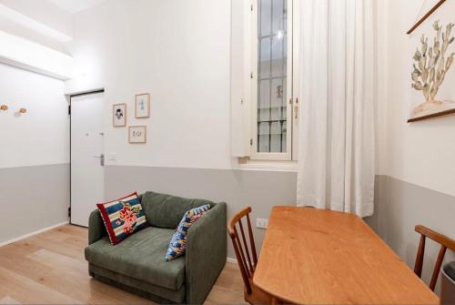 a living room with a green couch and a wooden table at Suite n15 - Design & Relax near the Navigli in Milan