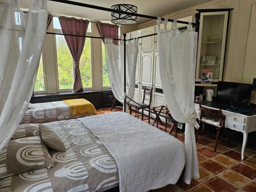a bedroom with two beds and a desk and a television at Le Berthoir in Pélussin