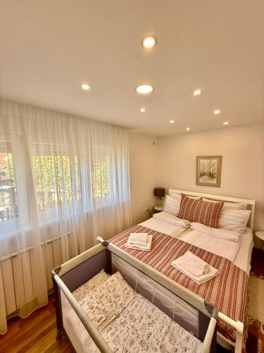 a bedroom with a large bed and a window at No1 Apartments in heart of Sarajevo in Sarajevo