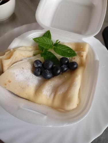 a white plate with a dessert with blueberries on it at Osada Szczyrk - prywatna sauna&jacuzzi in Szczyrk