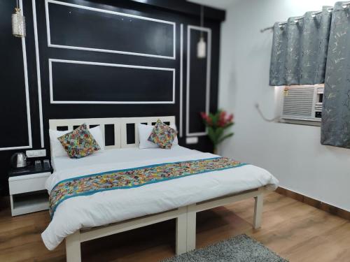 a bed with a black headboard in a room at Agrah Stay - Kasa Lusso Stay in Faridabad