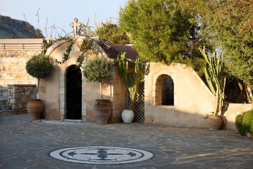 a house with a mosaic floor in a courtyard at Aquagrand Artistic Luxury Beach Resort - Adults Only in Líndos