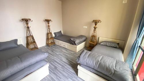 a room with two beds and a couch at Verve Nepal's Hostel in Kathmandu
