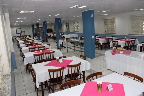 a dining room with white tables and pink napkins at Eventos & Hospedagem Sagrada Família in Sao Paulo
