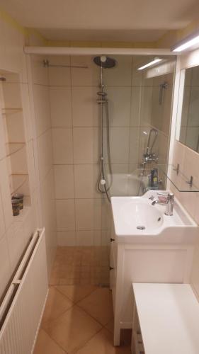 a white bathroom with a sink and a shower at Ferienhaus Frieda in Kurort Altenberg