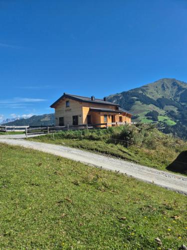 a house on a hill next to a dirt road at Lipphütte Top Lage mit traumhafter Aussicht in Rauris