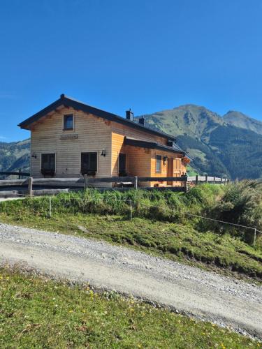 a house on a hill next to a road at Lipphütte Top Lage mit traumhafter Aussicht in Rauris