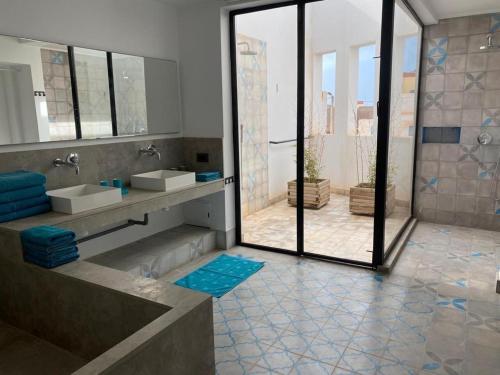 a bathroom with two sinks and a large mirror at Villa blanche in Mirleft