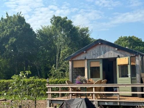 a small shack with chairs on a wooden deck at 't Hoevehuisje in Beverwijk