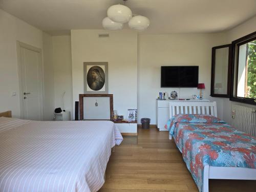 a bedroom with two beds and a flat screen tv at B&B Poggio di Vento sulla via degli Dei in Monzuno