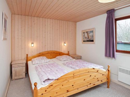 a bedroom with a wooden bed in a room at 4 person holiday home in Juelsminde-By Traum in Snaptun