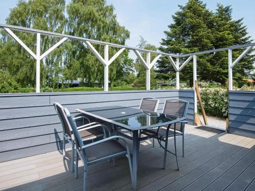 a patio with a table and chairs on a deck at 4 person holiday home in Juelsminde-By Traum in Snaptun