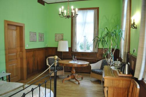 a living room with green walls and a table and chairs at Hotel Cramer Bed & Breakfast in Werlte