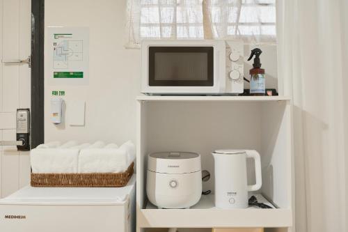 d'un four micro-ondes et d'une cafetière sur une étagère. dans l'établissement Nonhyeon House, à Séoul