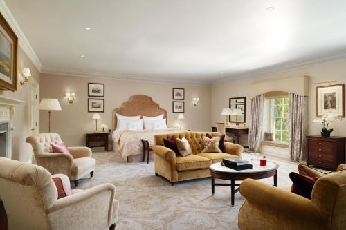 a hotel room with a bed and a couch and chairs at Grantley Hall in Ripon