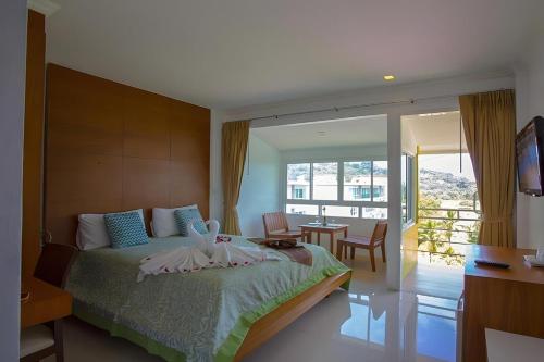 une chambre avec un grand lit et un balcon dans l'établissement Sukcheewa Residence Phuket, à Patong Beach