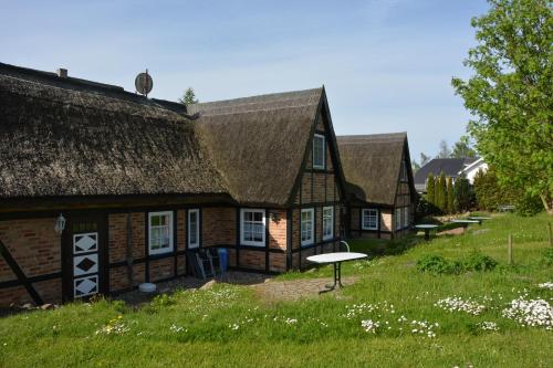 an old house with a thatched roof and a table at Reethäuser auf Rügen in Middelhagen