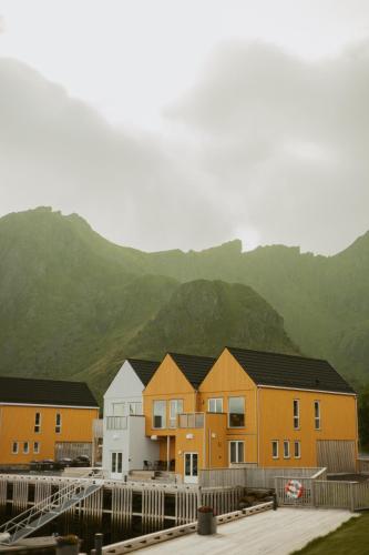 a row of houses with mountains in the background at #Lofoten Leilighet ved sjøen in Ballstad