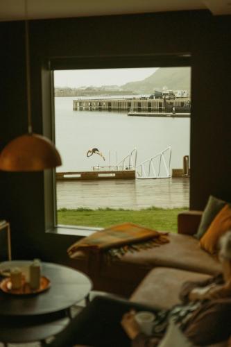 a room with a large window with a view of a dock at #Lofoten Leilighet ved sjøen in Ballstad