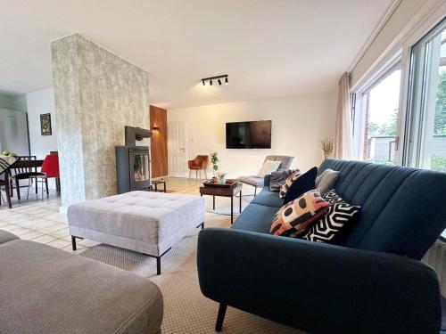 a living room with a blue couch and a fireplace at 92 qm - Premium Unterkunft - Wibbelt No 23 in Greven