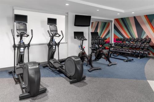 a fitness room with treadmills and exercise bikes at Hilton Garden Inn Queens JFK in Queens