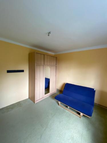 a room with a blue bed and a cabinet at Tisá byt in Ústí nad Labem