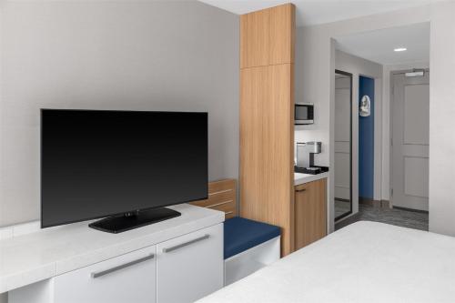 a room with a flat screen tv on a counter at Hilton Garden Inn Queens JFK in Queens